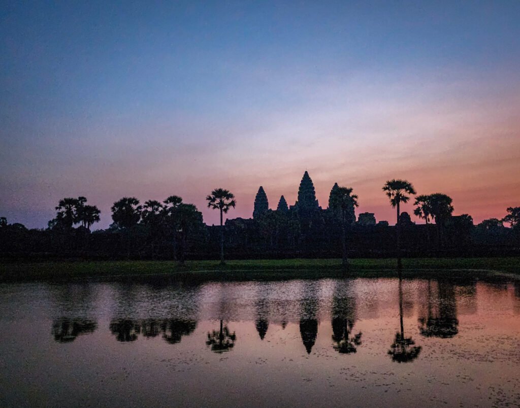 Angkor Wat at sunrise reflected in the still waters of the reflecting pool, Siem Reap, Cambodia